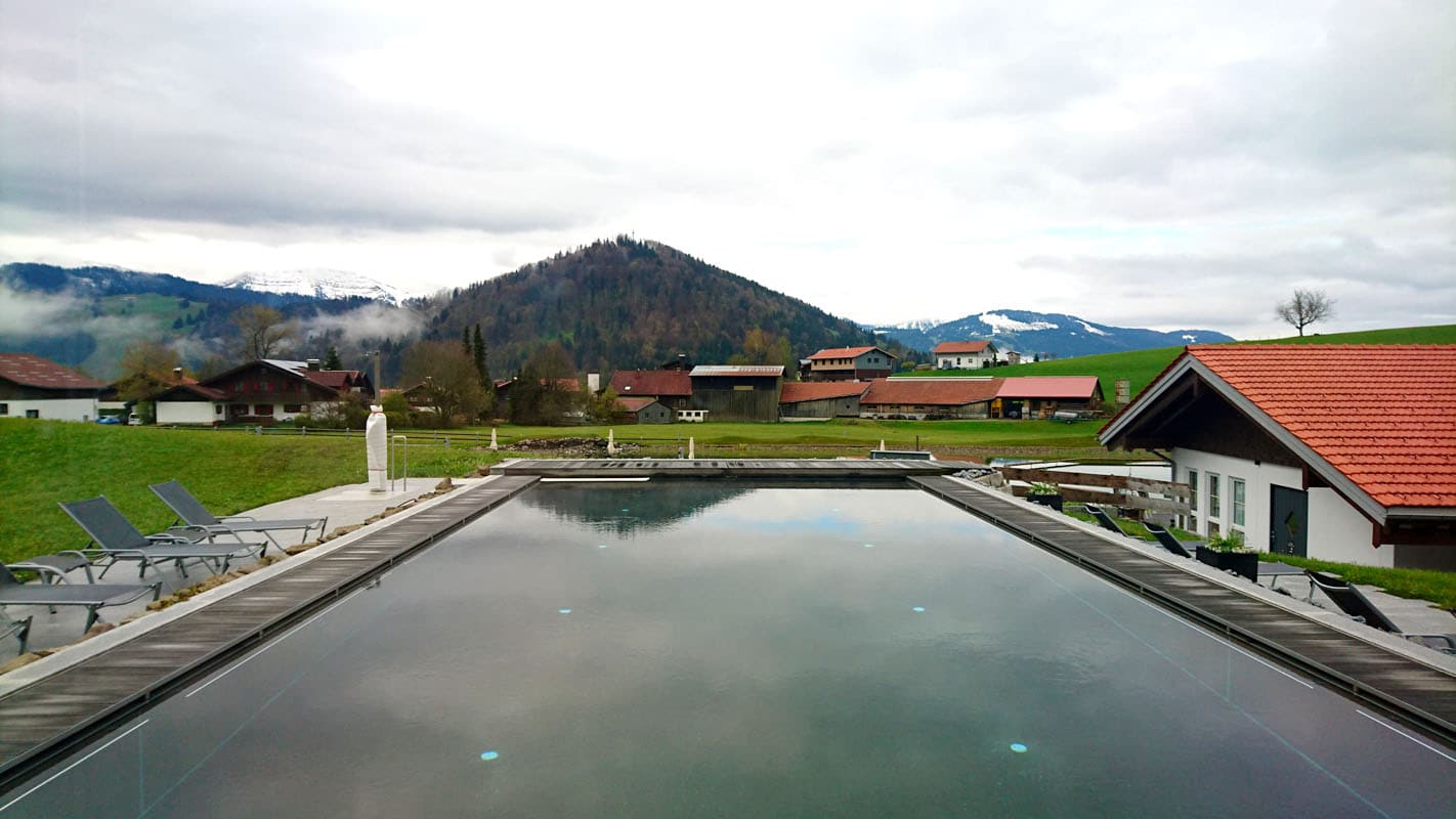 haubers-alpenresort-oberstaufen-allgaeu-bayern-hoteltipp-deutschland-haus-am-see-einstieg-outdoor-pool