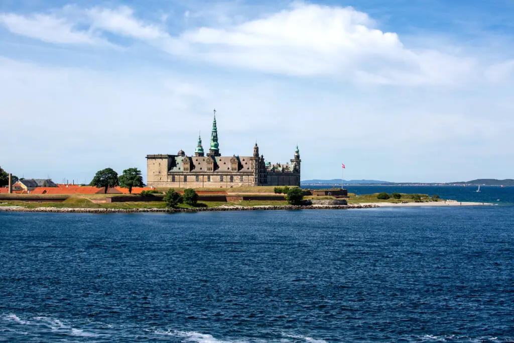 Blick auf die majestätische Burg Kronborg in Helsingør, Dänemark, umgeben vom klaren Wasser der Ostsee an einem sonnigen Tag