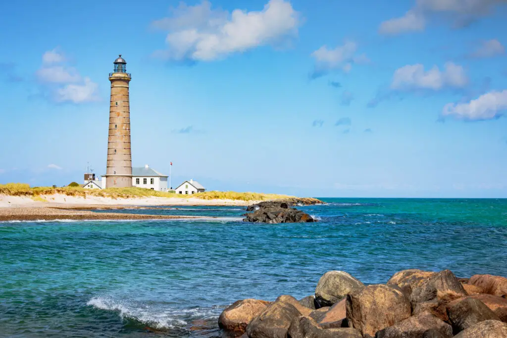 Der malerische Leuchtturm in Skagen, Dänemark, thront auf einem felsigen Uferstreifen und überblickt die weite, blaue Nordsee.